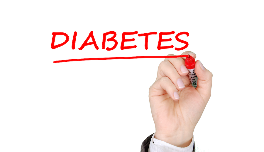 Image of a whiteboard with a hand writing "Diabetes" in red marker. Diabetes affects oral health. 